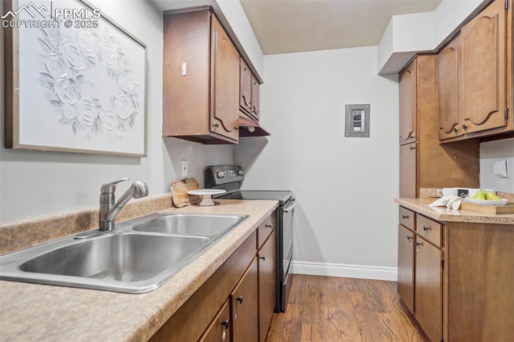 2902 Airport Road, Unit 116 Colorado Springs, CO 80910 - Photo 13 of 32 a kitchen with stainless steel appliances granite countertop a sink and dishwasher with wooden floor