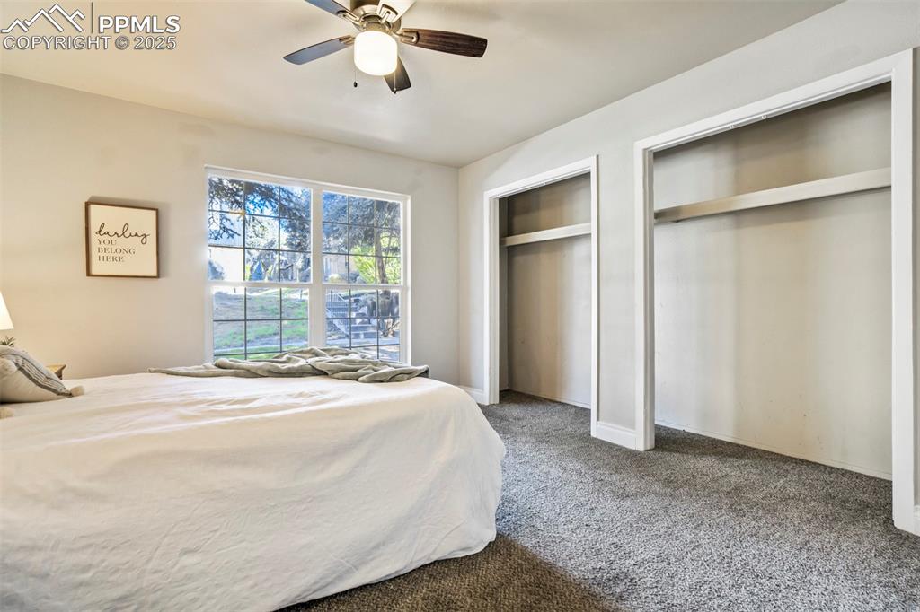 2902 Airport Road, Unit 116 Colorado Springs, CO 80910 - Photo 17 of 32 a spacious bedroom with a bed and a chandelier