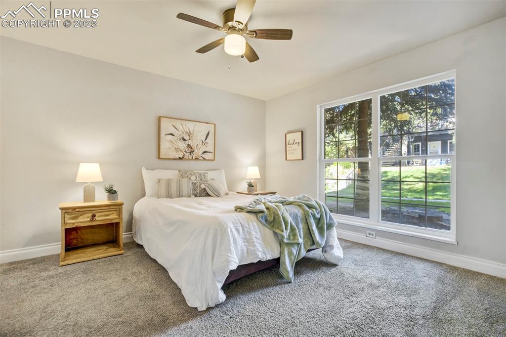 2902 Airport Road, Unit 116 Colorado Springs, CO 80910 - Photo 18 of 32 a spacious bedroom with a bed and a chandelier