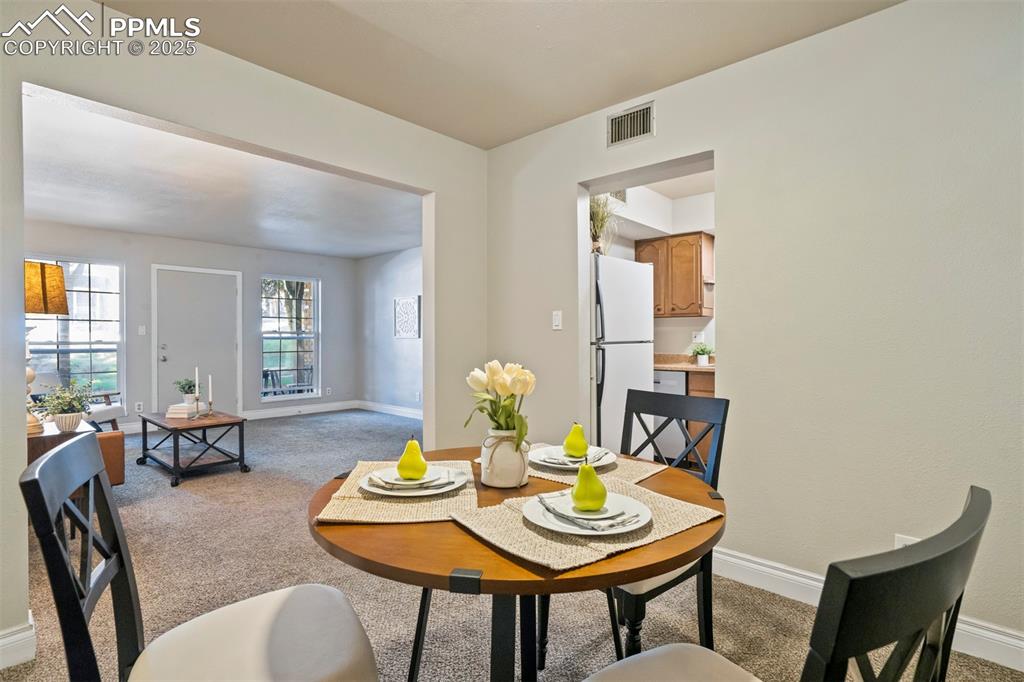2902 Airport Road, Unit 116 Colorado Springs, CO 80910 - Photo 4 of 32 a view of a dining room with furniture and wooden floor