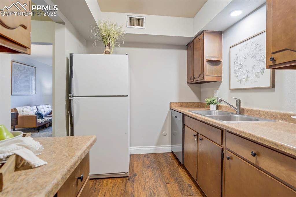 2902 Airport Road, Unit 116 Colorado Springs, CO 80910 - Photo 5 of 32 a kitchen with sink refrigerator and cabinets