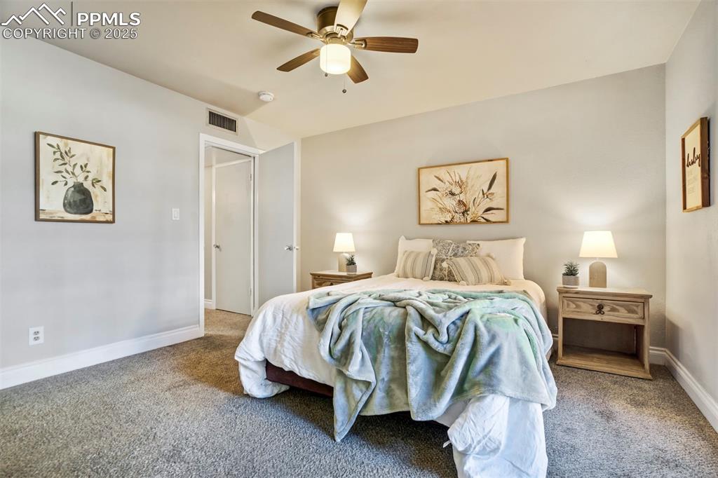 2902 Airport Road, Unit 116 Colorado Springs, CO 80910 - Photo 6 of 32 a bedroom with a bed and a chandelier