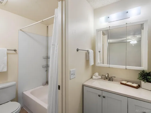 a white toilet sitting next to a bath tub and a shower