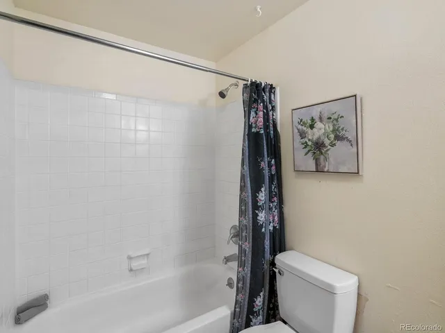 an empty room with a ceiling fan and a window