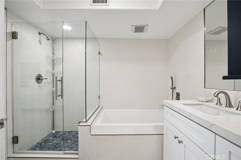 200 Pacific Coast Highway, Unit 130 Huntington Beach, CA 92648 - Photo 18 of 36 a bathroom with a shower sink and mirror