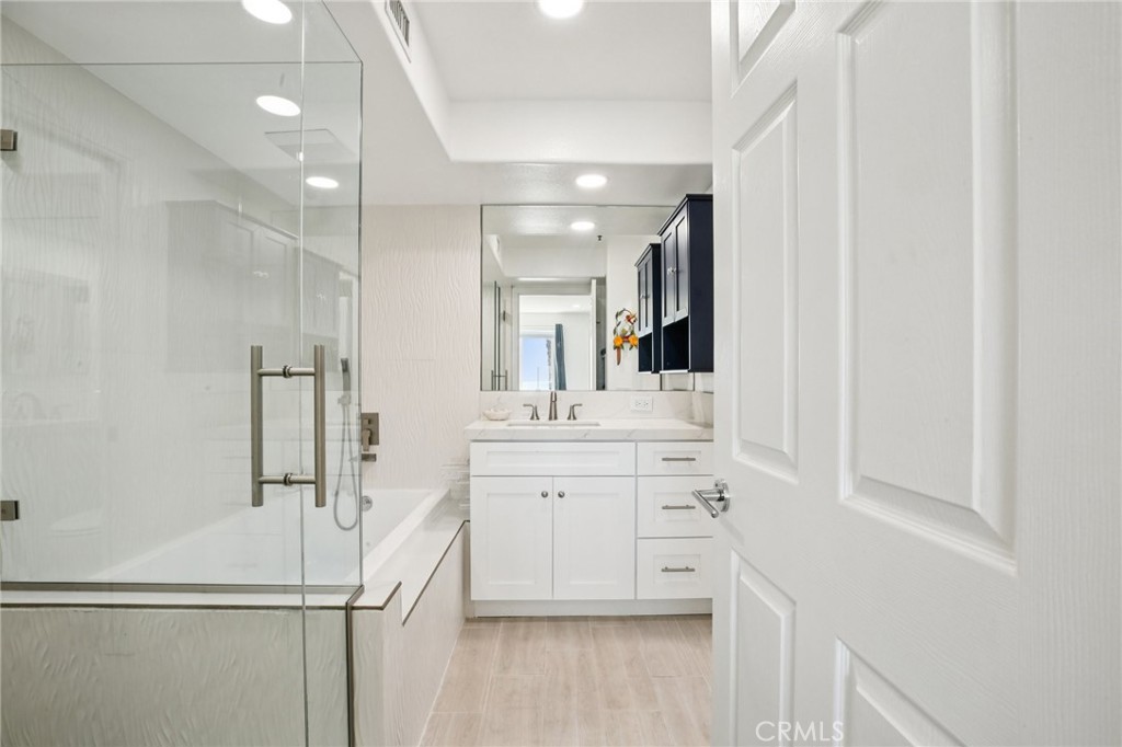 200 Pacific Coast Highway, Unit 130 Huntington Beach, CA 92648 - Photo 19 of 36 a bathroom with a shower sink and mirror
