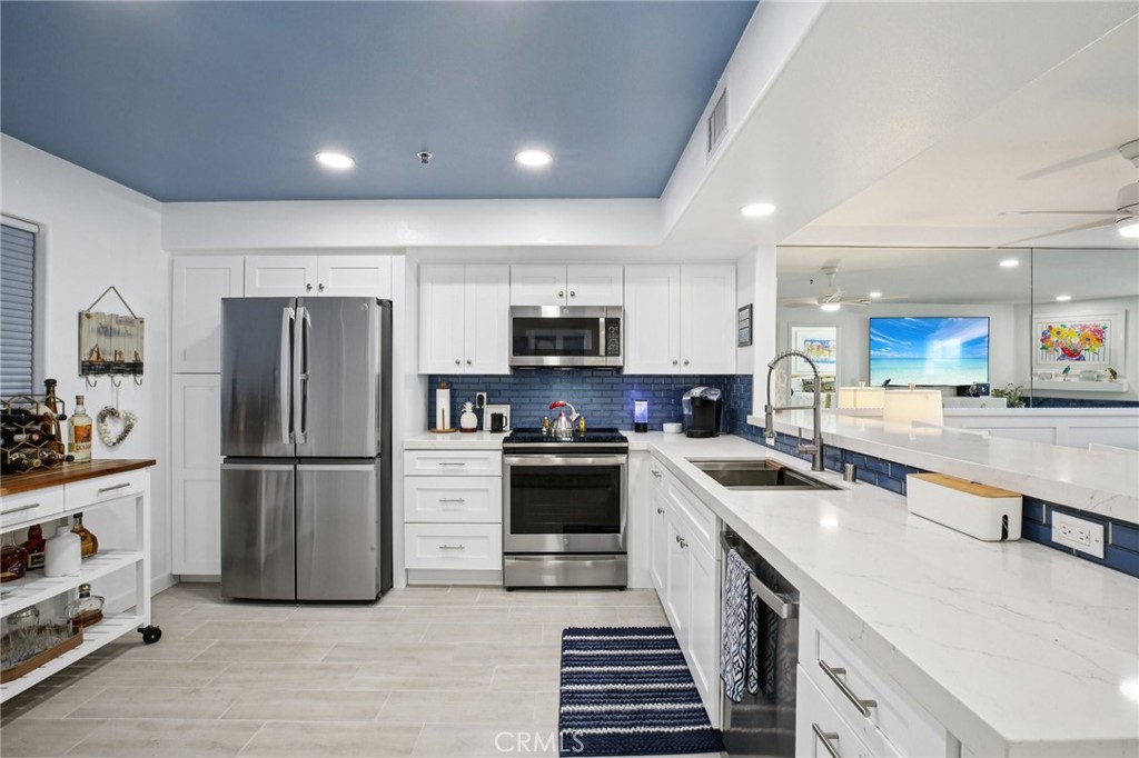 200 Pacific Coast Highway, Unit 130 Huntington Beach, CA 92648 - Photo 8 of 36 a kitchen with a refrigerator a stove and a sink