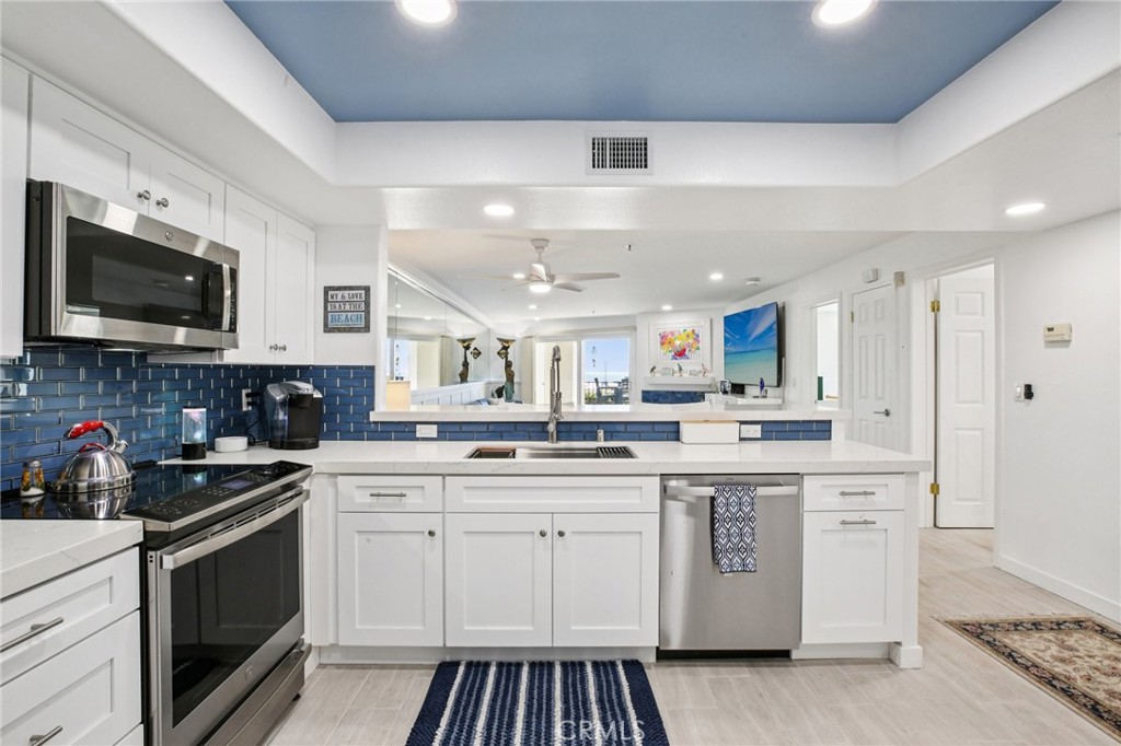 200 Pacific Coast Highway, Unit 130 Huntington Beach, CA 92648 - Photo 9 of 36 a kitchen with stainless steel appliances granite countertop a sink and stove top oven