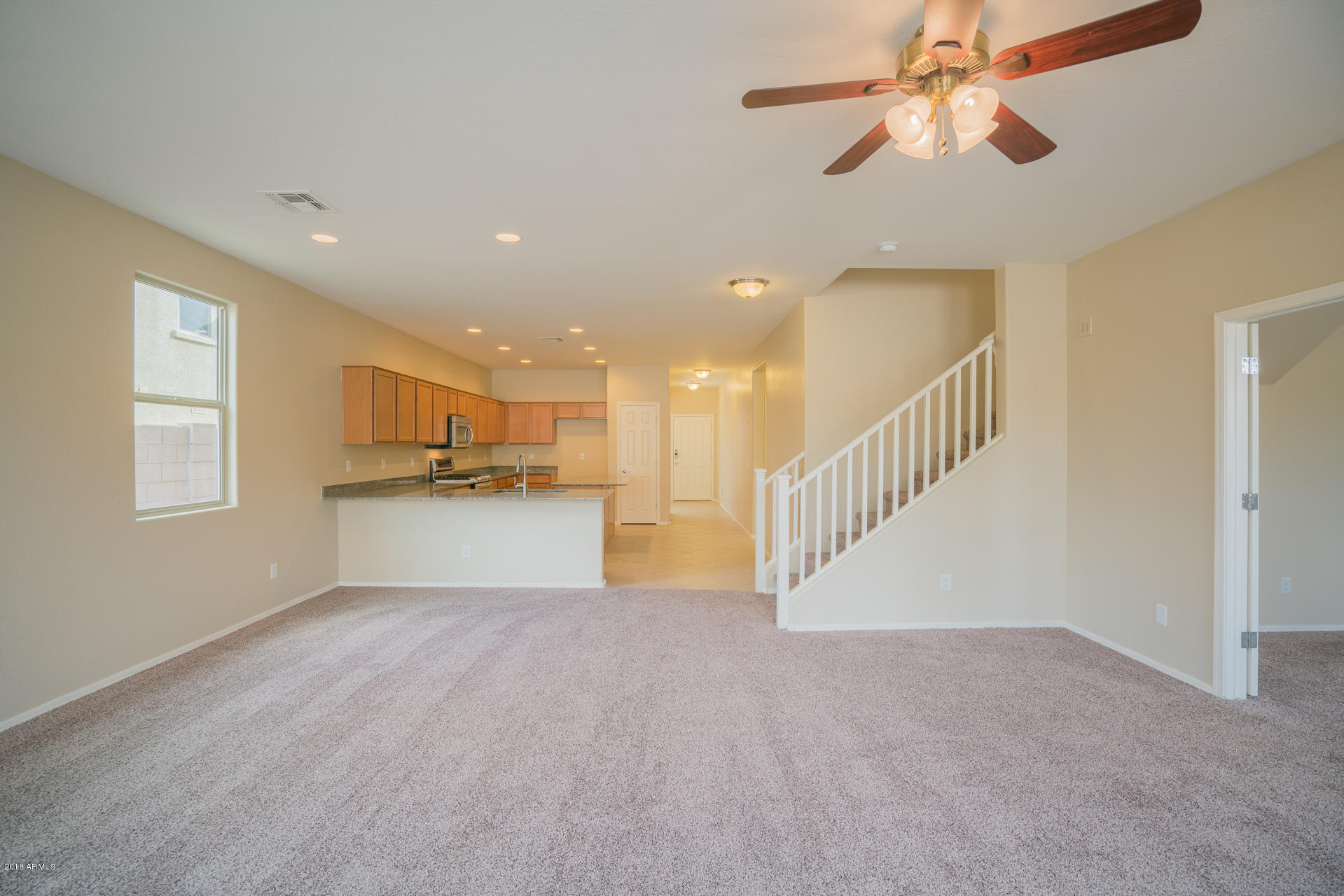 18206 West Hatcher Road Waddell, AZ 85355 - Photo 8 of 27 a view of an empty room with a window and kitchen view
