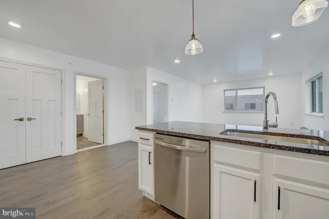 a kitchen with stainless steel appliances granite countertop a sink and dishwasher with white cabinets