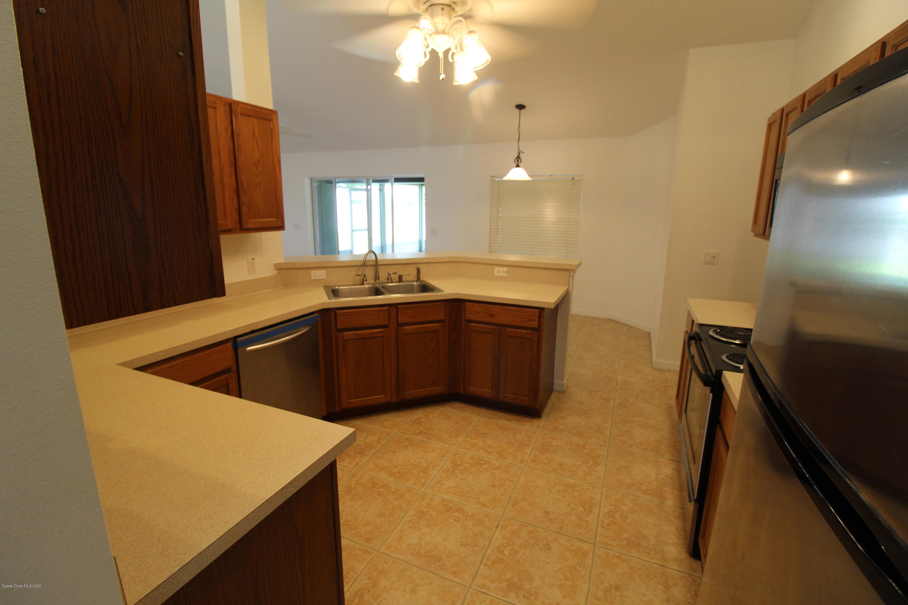 2004 Gloria Circle Palm Bay, FL 32905 - Photo 11 of 36 a kitchen with sink cabinets and chandelier