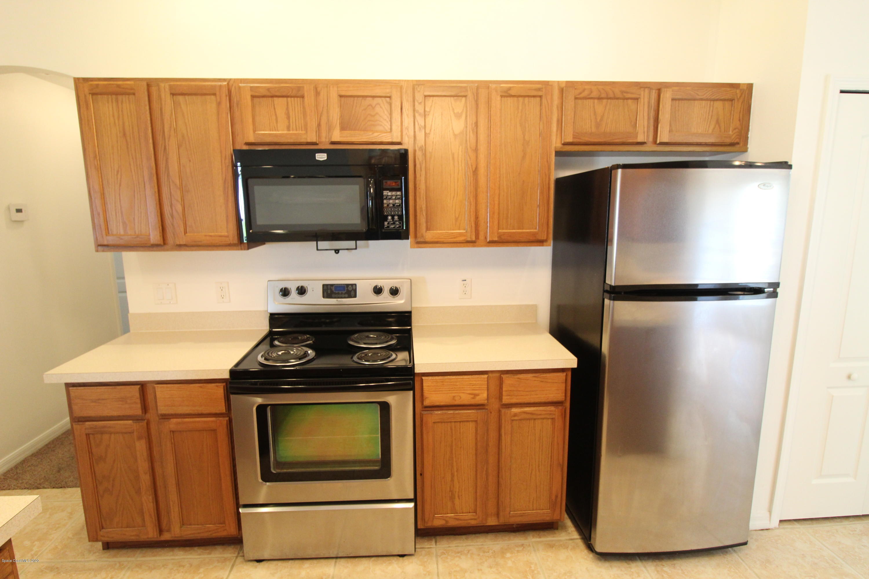 2004 Gloria Circle Palm Bay, FL 32905 - Photo 13 of 36 a kitchen with granite countertop a refrigerator stove and microwave