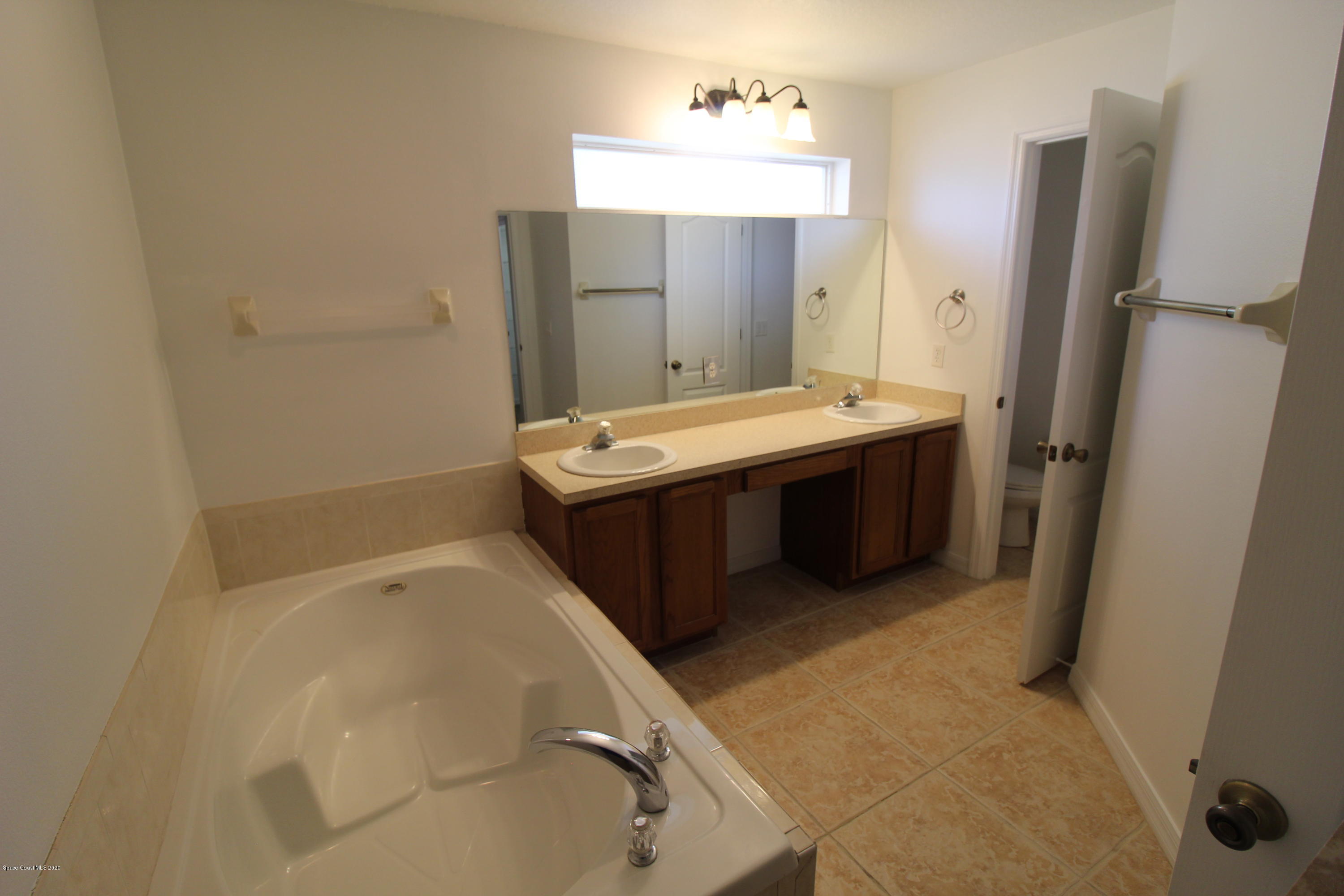 2004 Gloria Circle Palm Bay, FL 32905 - Photo 18 of 36 a bathroom with a tub sink and mirror