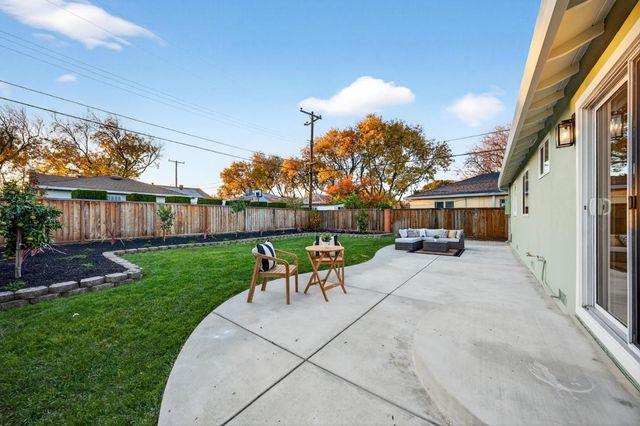 a view of a patio with table and chairs with wooden fence