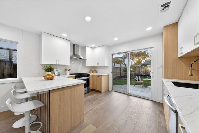 a kitchen with a sink and chairs