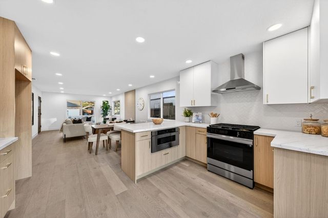 a kitchen with a stove and white cabinets