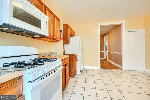 a kitchen with granite countertop a stove a sink and a microwave