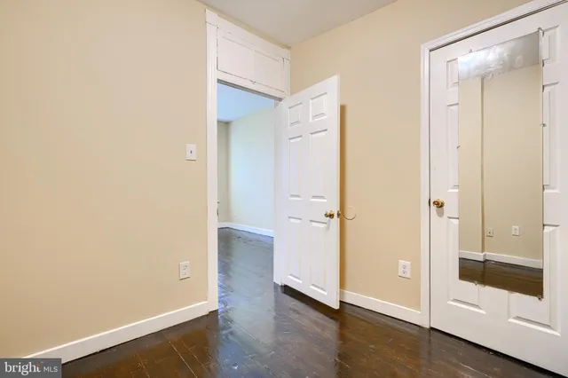 an empty room with wooden floor and door