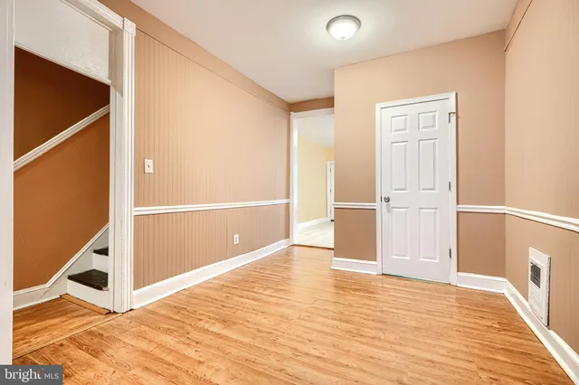 a view of a hallway with wooden floor and entryway