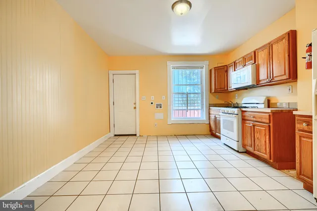 a view of a kitchen with stainless steel appliances granite countertop a refrigerator and a stove top oven