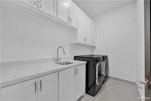 a utility room with sink dryer and washer
