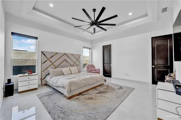 a bedroom with a large bed and a chandelier