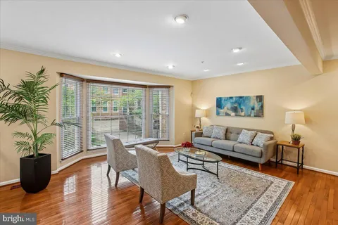 a living room with furniture and a dining table with rug