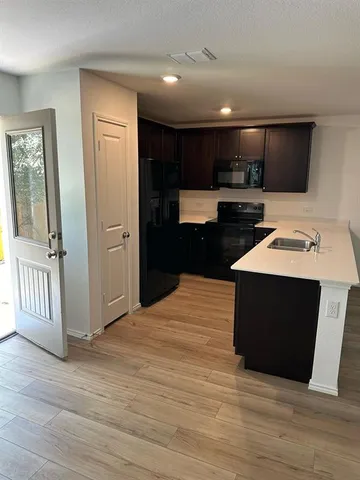 a kitchen with stainless steel appliances kitchen island granite countertop a stove top oven and sink