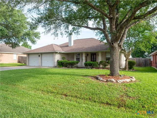 a front view of a house with a yard and trees