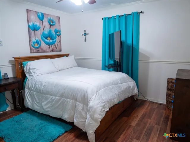 a bedroom with a bed and a painting on the wall