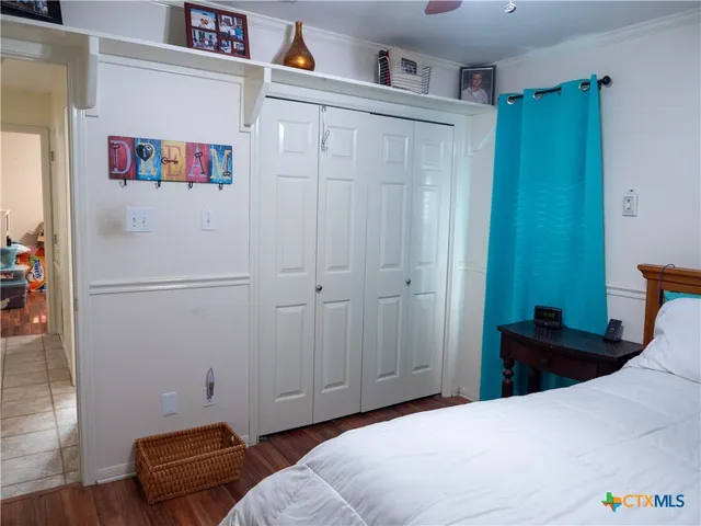 a bedroom with a bed and a refrigerator
