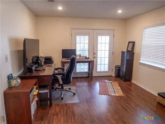 a view of a workspace with furniture and a window