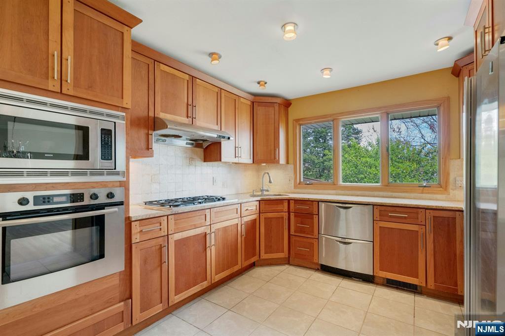 9 Hemlock Drive Paramus, NJ 07652 - Photo 16 of 35 a kitchen with stainless steel appliances granite countertop a stove sink and microwave