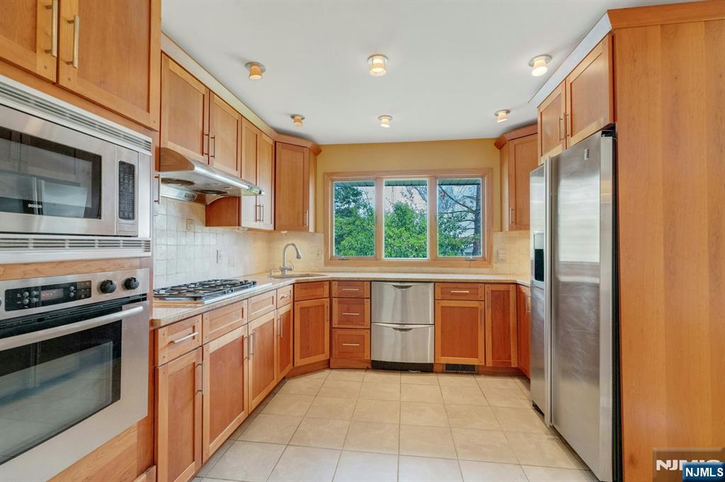 9 Hemlock Drive Paramus, NJ 07652 - Photo 17 of 35 a kitchen with stainless steel appliances granite countertop a stove and a refrigerator