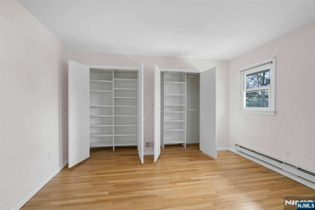 9 Hemlock Drive Paramus, NJ 07652 - Photo 26 of 35 an empty room with walk in closet and wooden floor