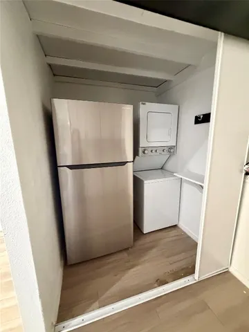 a kitchen with wooden floor and appliances