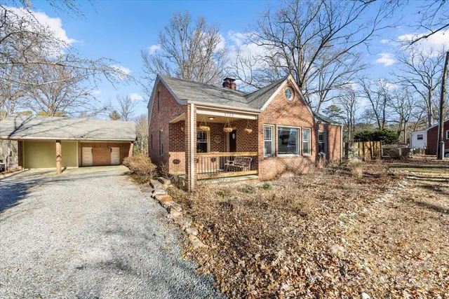 a view of a house with a yard and large trees