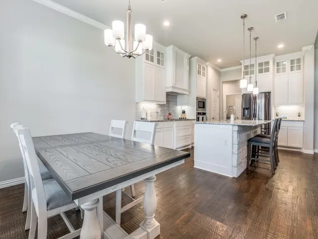 a kitchen with a table chairs and microwave