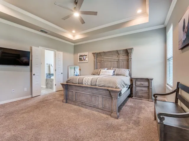 a bedroom with a bed and dresser with wooden floor