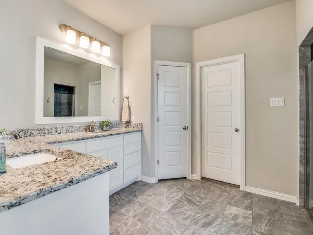 a bathroom with a granite countertop sink and a mirror