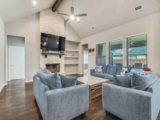 a living room with furniture a flat screen tv and a fireplace