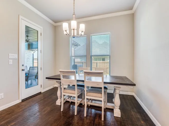 a view of a dining room with furniture wooden floor and chandelier
