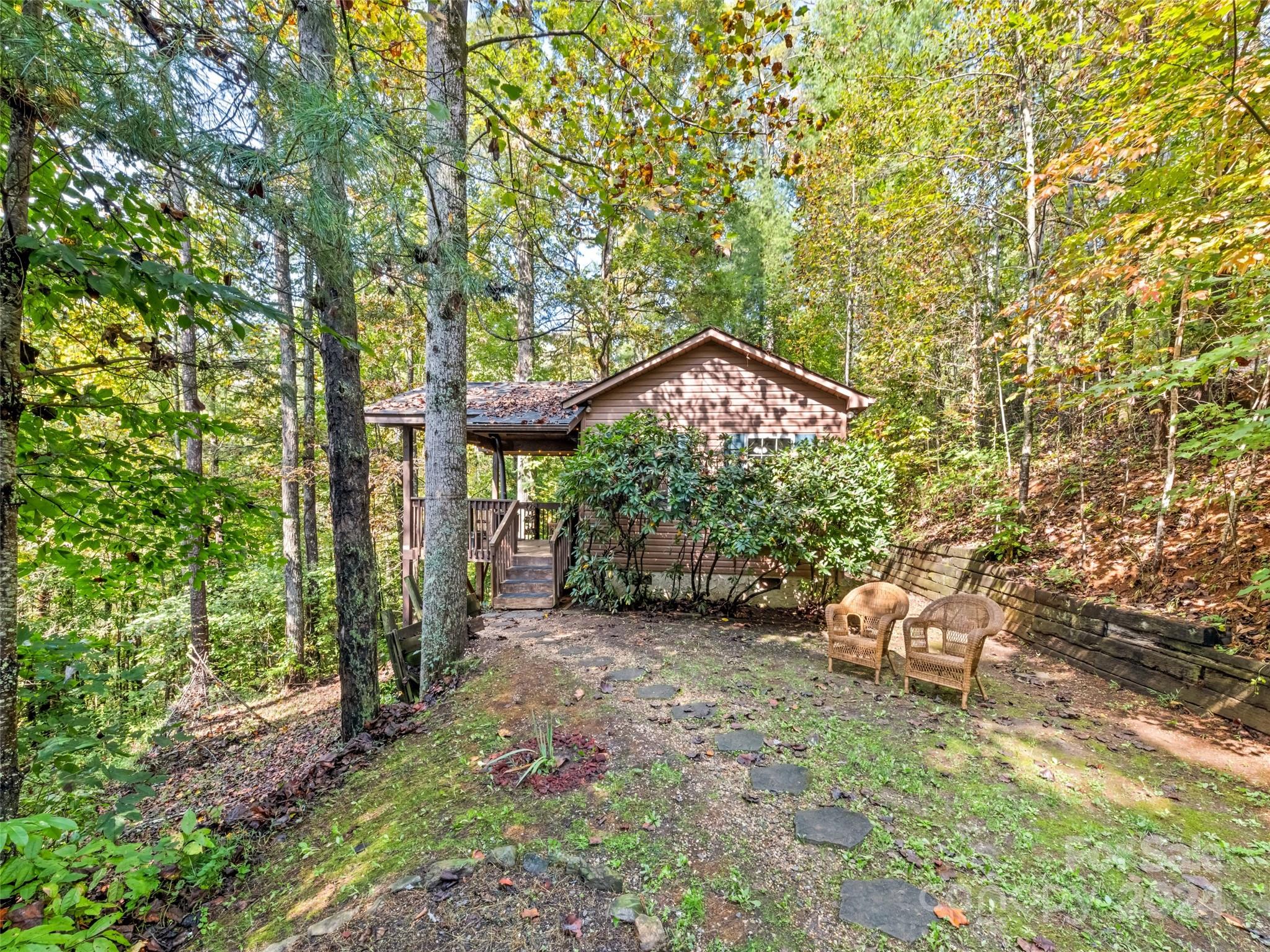 626 Rustic Heights Road Waynesville, NC 28785 - Photo 1 of 18 a view of a chair and table in the garden