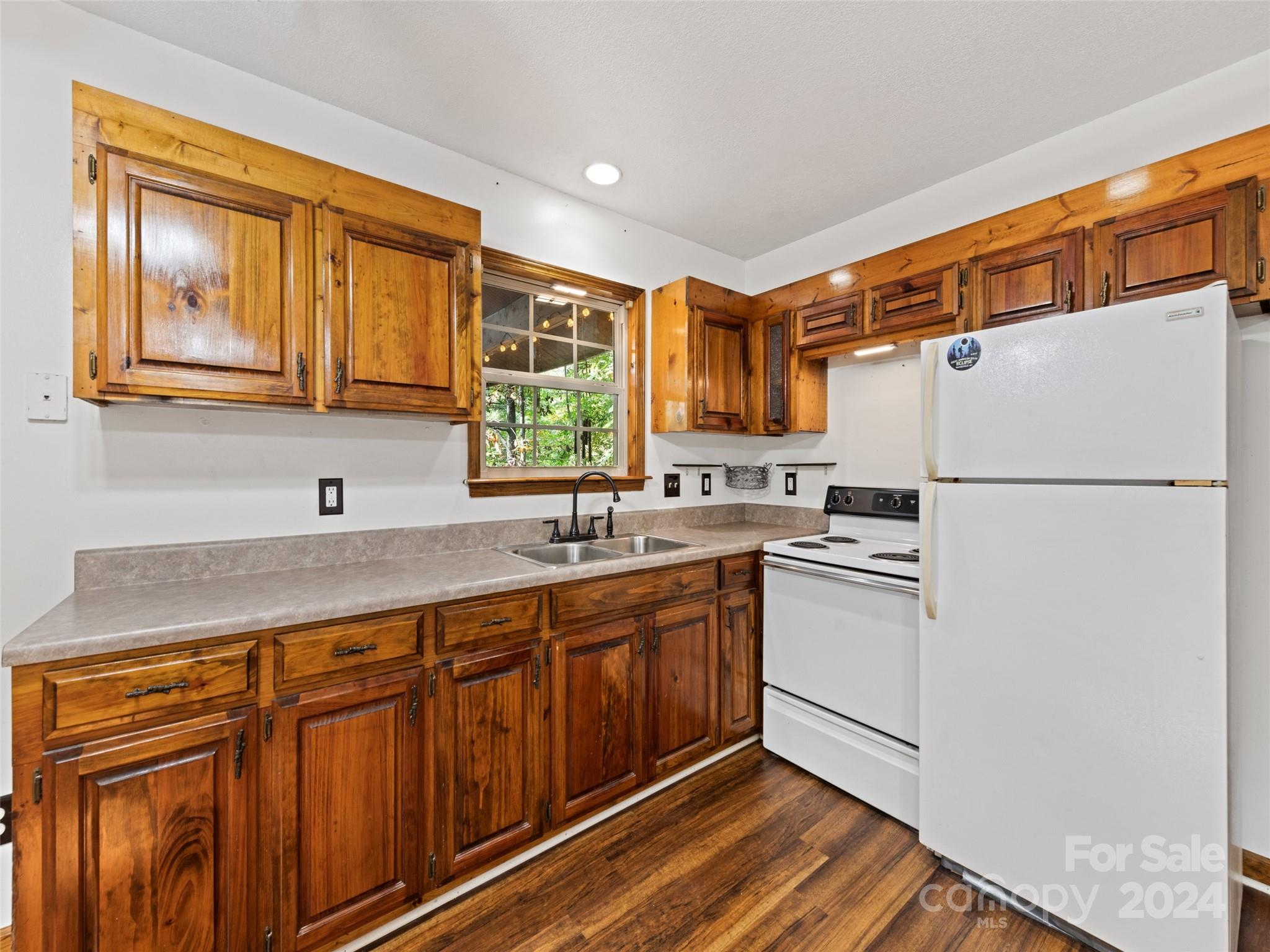 626 Rustic Heights Road Waynesville, NC 28785 - Photo 13 of 18 a kitchen with stainless steel appliances granite countertop a refrigerator a sink dishwasher a stove with wooden cabinets and floor