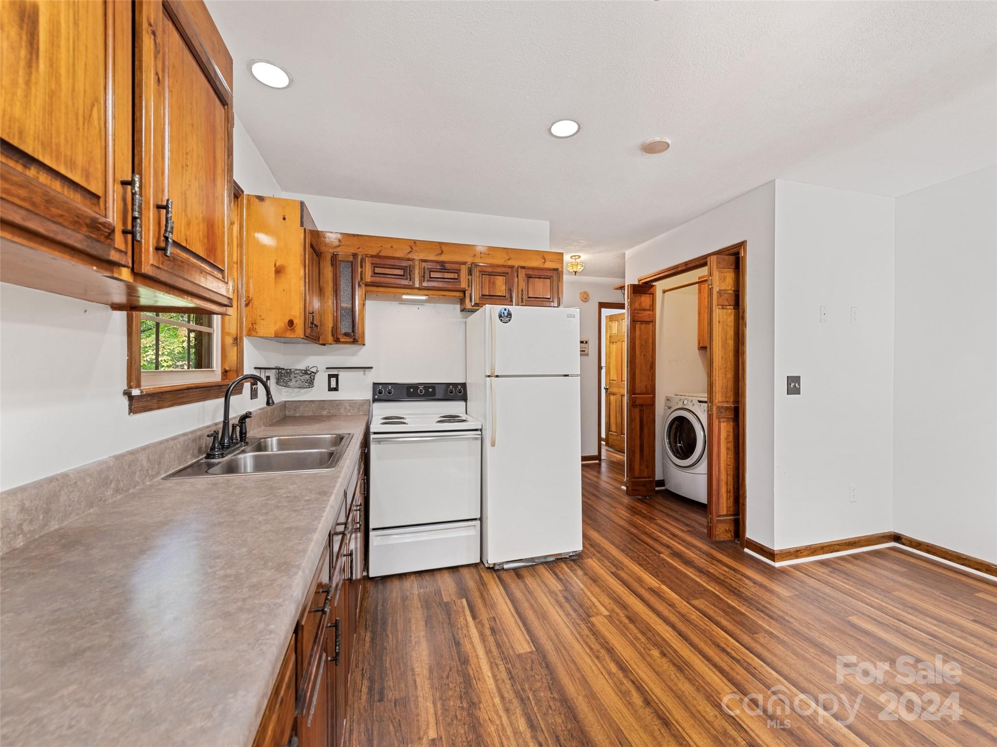 626 Rustic Heights Road Waynesville, NC 28785 - Photo 14 of 18 a kitchen with wooden floor and electronic appliances