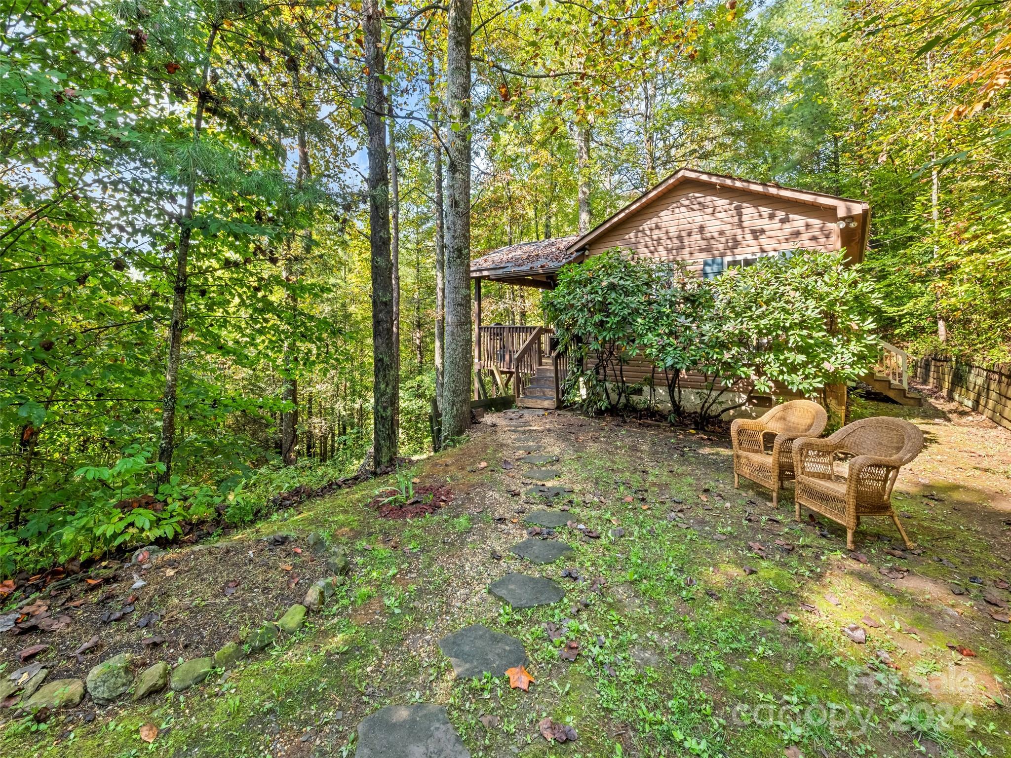 626 Rustic Heights Road Waynesville, NC 28785 - Photo 2 of 18 a backyard of a house with table and chairs