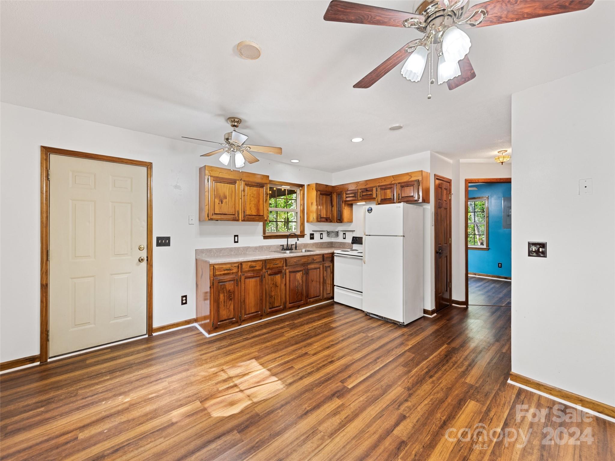 626 Rustic Heights Road Waynesville, NC 28785 - Photo 8 of 18 a kitchen with stainless steel appliances a stove top oven a refrigerator cabinets and wooden floor