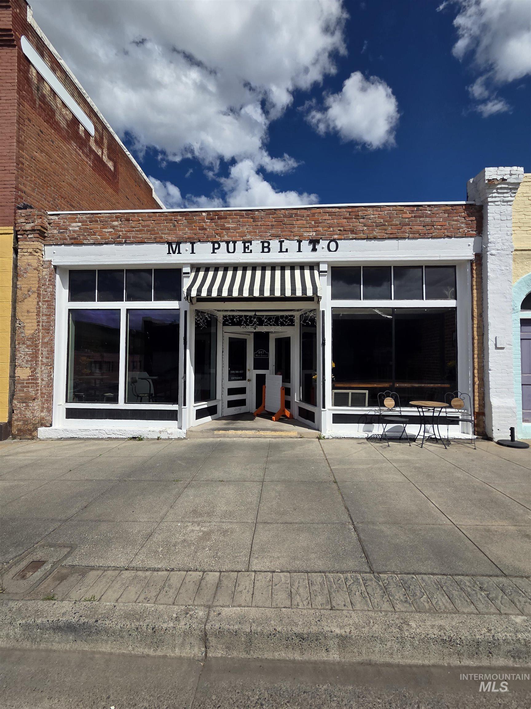 Commercial storefront featuring a brick facade with a white frieze