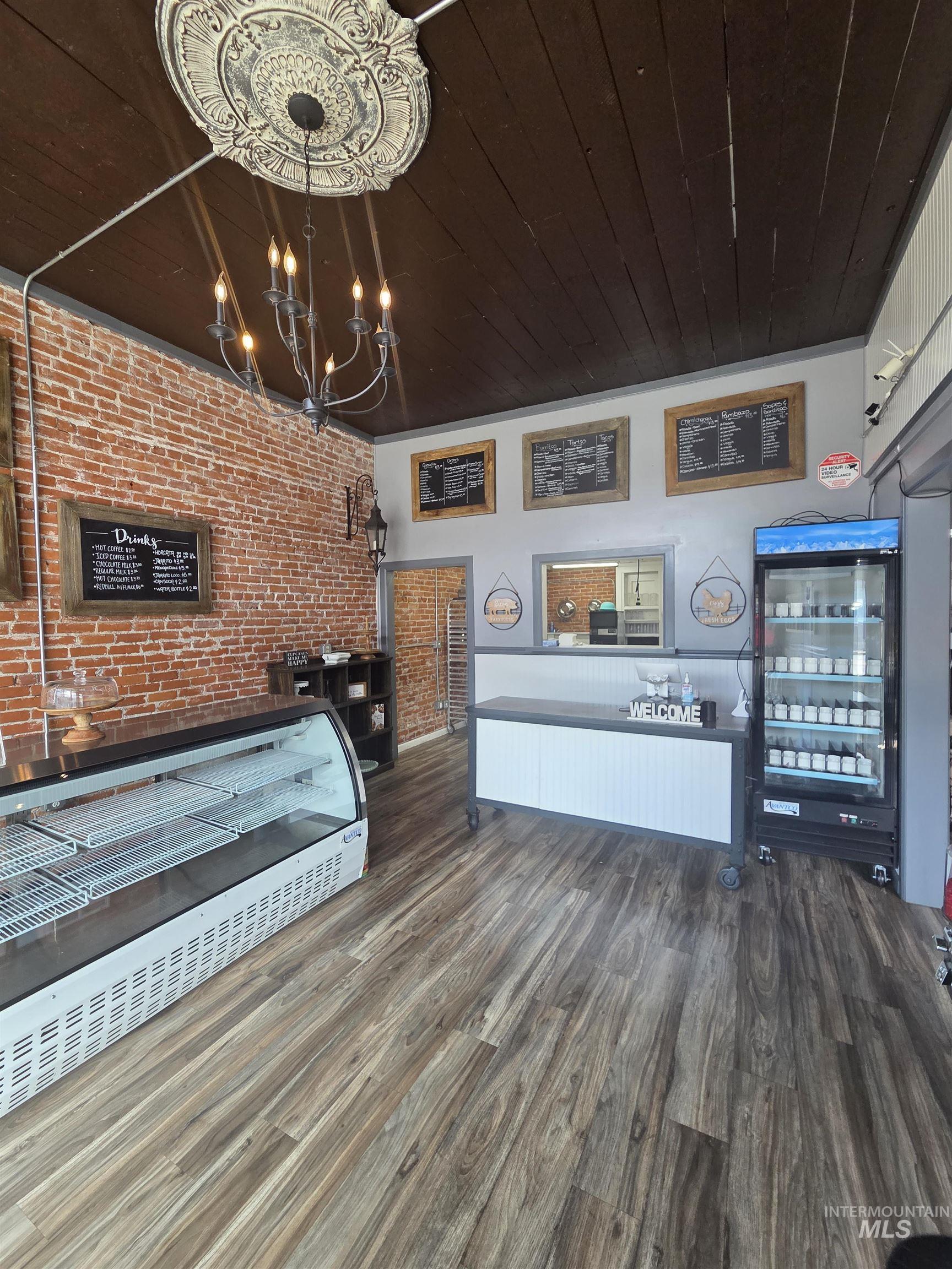 847 Main Street Pomeroy, WA 99347 - Photo 3 of 12 Exposed brick wall accents a dark wood-finish ceiling with a decorative ceiling medallion