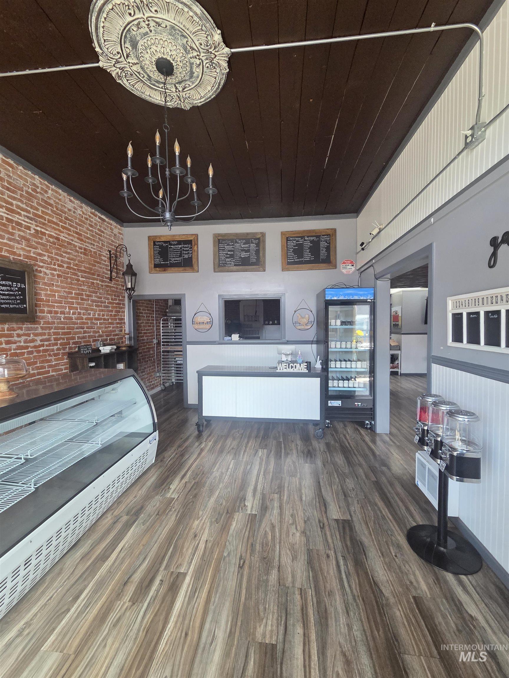 847 Main Street Pomeroy, WA 99347 - Photo 4 of 12 Spacious interior featuring wood-finish flooring, exposed brick accents, and a dark wood plank ceiling
